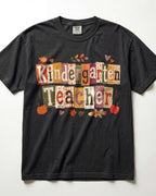 Black crew-neck short-sleeve T-shirt with “Kindergarten Teacher” fall graphic print