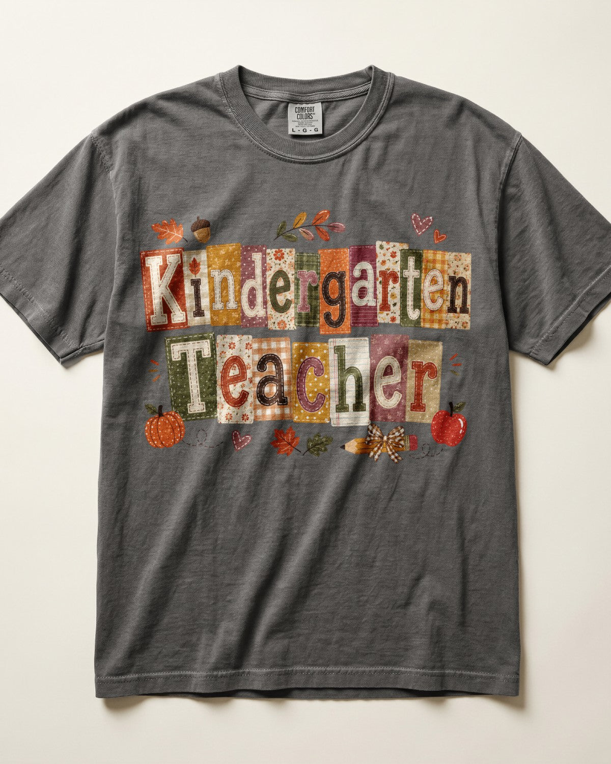 Dark gray crew-neck short-sleeve T-shirt with “Kindergarten Teacher” fall graphic print