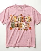 Pink crew-neck short-sleeve T-shirt with “Kindergarten Teacher” fall graphic print