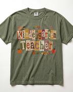 Olive green crew-neck short-sleeve T-shirt with “Kindergarten Teacher” fall graphic print