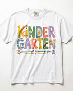 A white t-shirt with colorful text and illustrations that say "KINDER GARTEN" and "where bright beginnings grow".