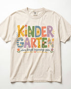 An ivory t-shirt with colorful text that says "KINDER GARTEN" and "where bright beginnings grow".