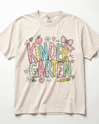 Cream kindergarten teacher T-shirt with colorful “Kinder Garden” graphic and pencils