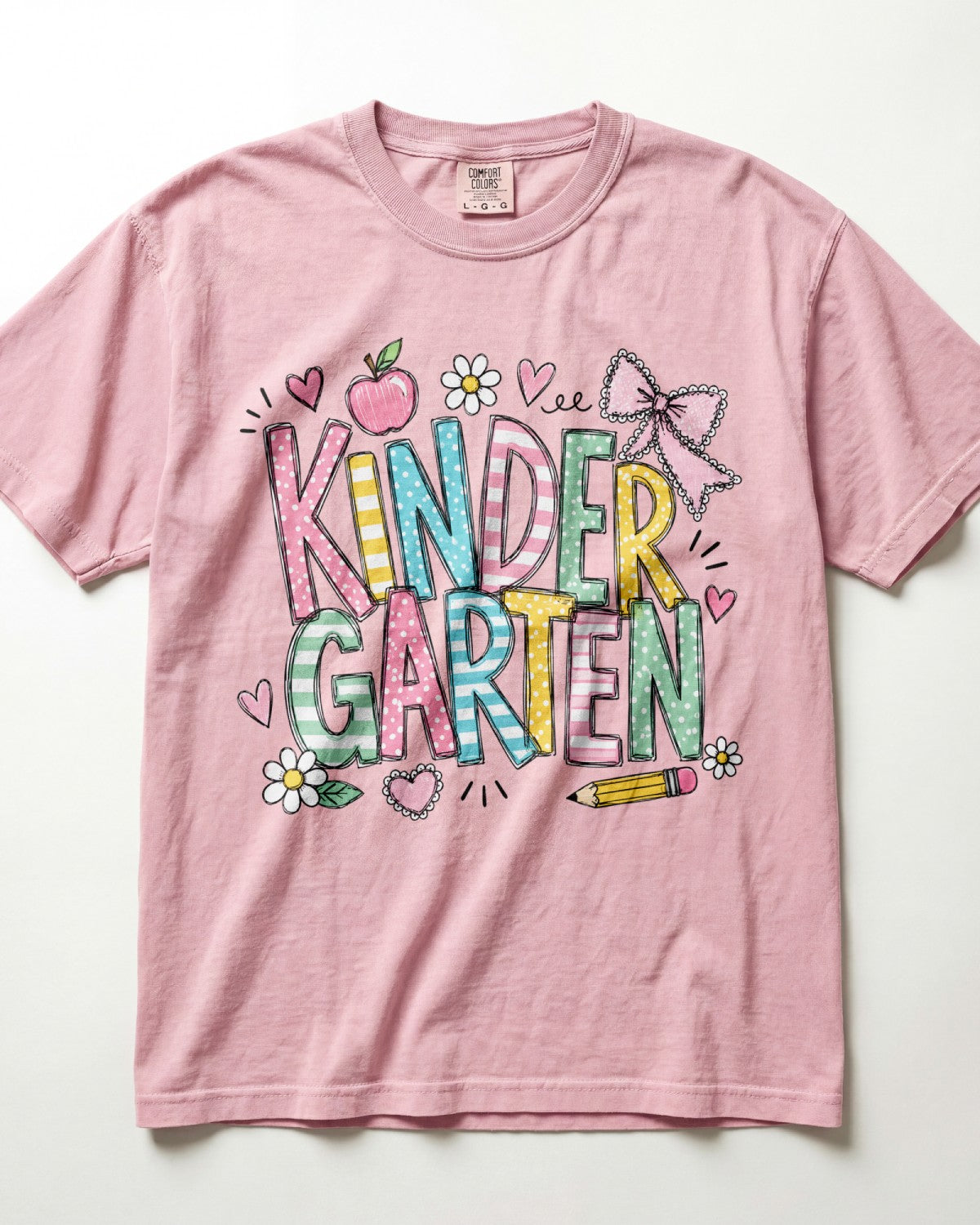 Light pink kindergarten teacher T-shirt with colorful “Kinder Garden” graphic and pencils