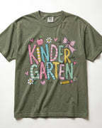 Olive green kindergarten teacher T-shirt with colorful “Kinder Garden” graphic and pencils