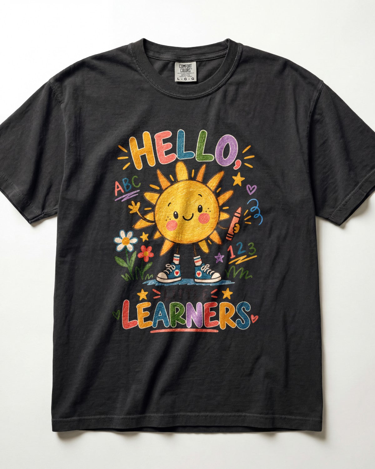 A black short-sleeve t-shirt with a colorful graphic on the front featuring a smiling sun, flowers, and the text 'HELLO LEARNERS'.